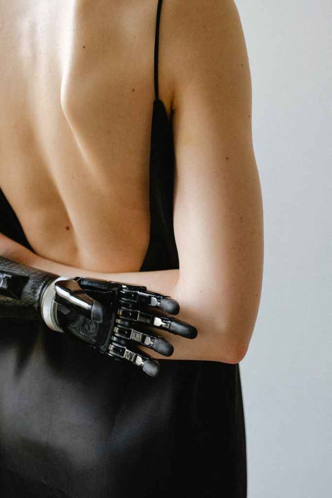 A person with a prosthetic arm stands with their back to us. 
