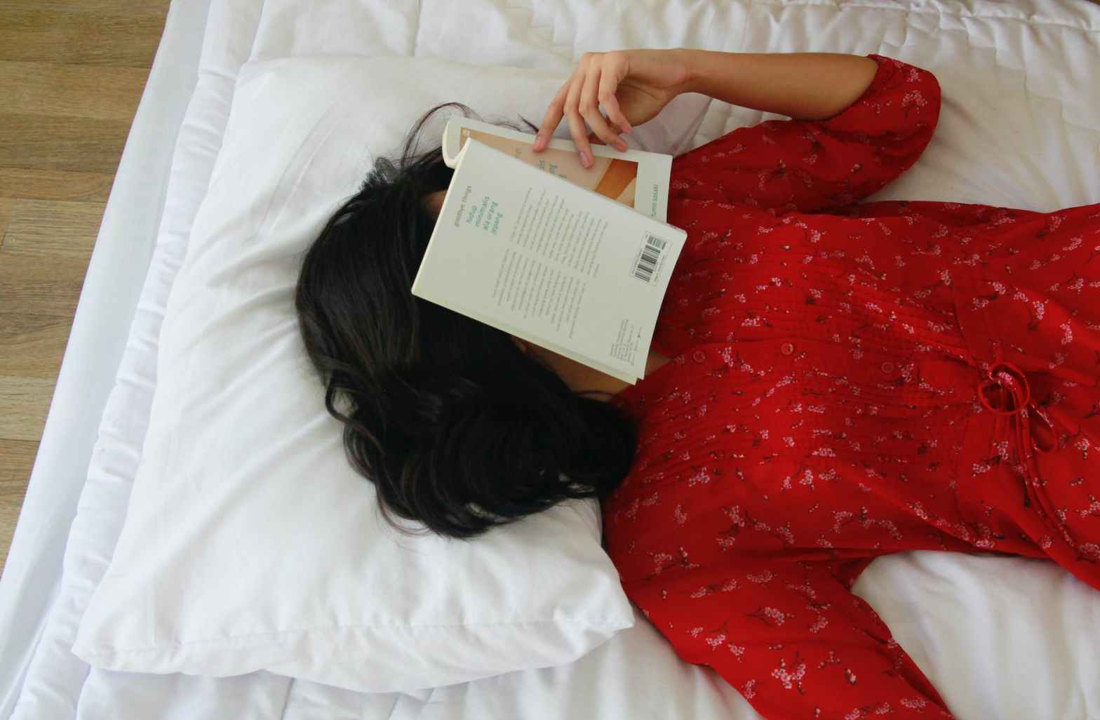 a woman in red dress lying on the bed