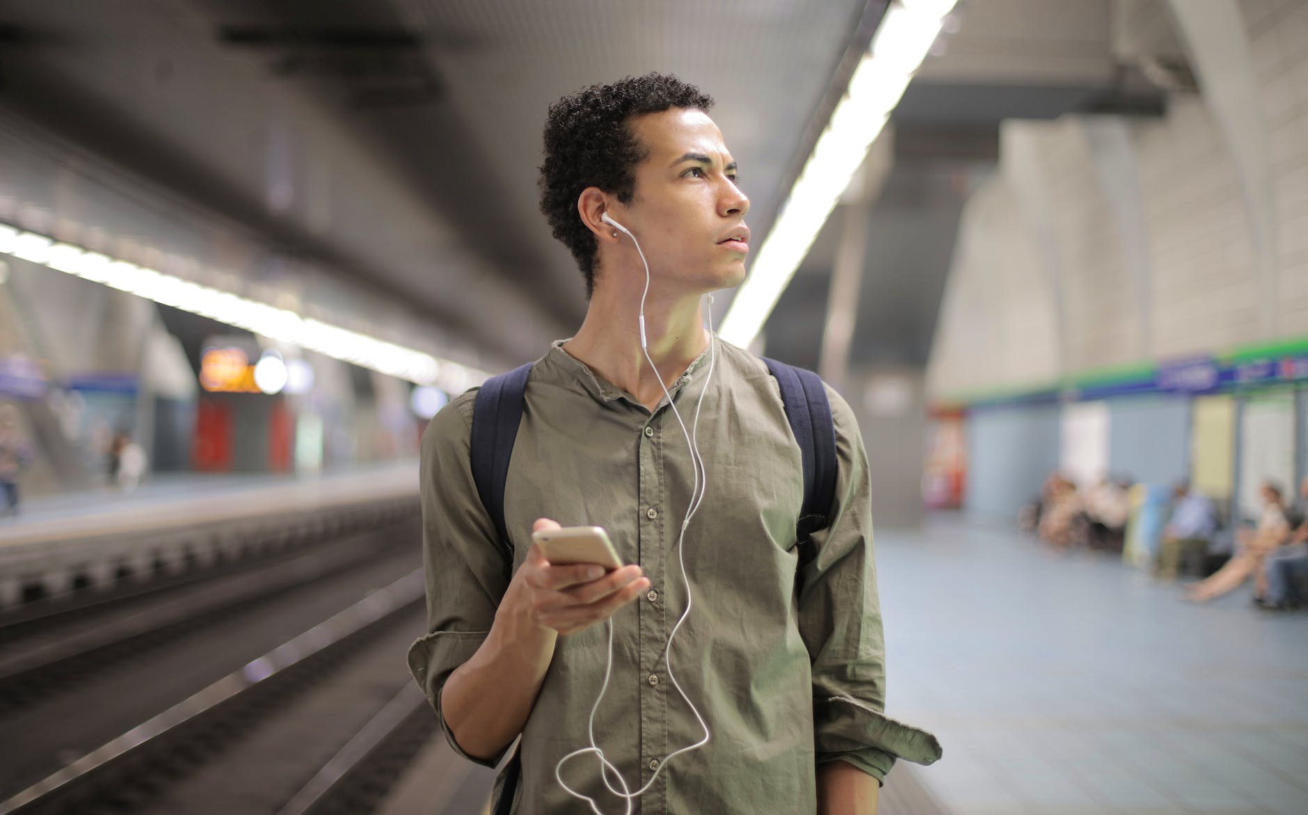 A nervous looking person walks through a train station